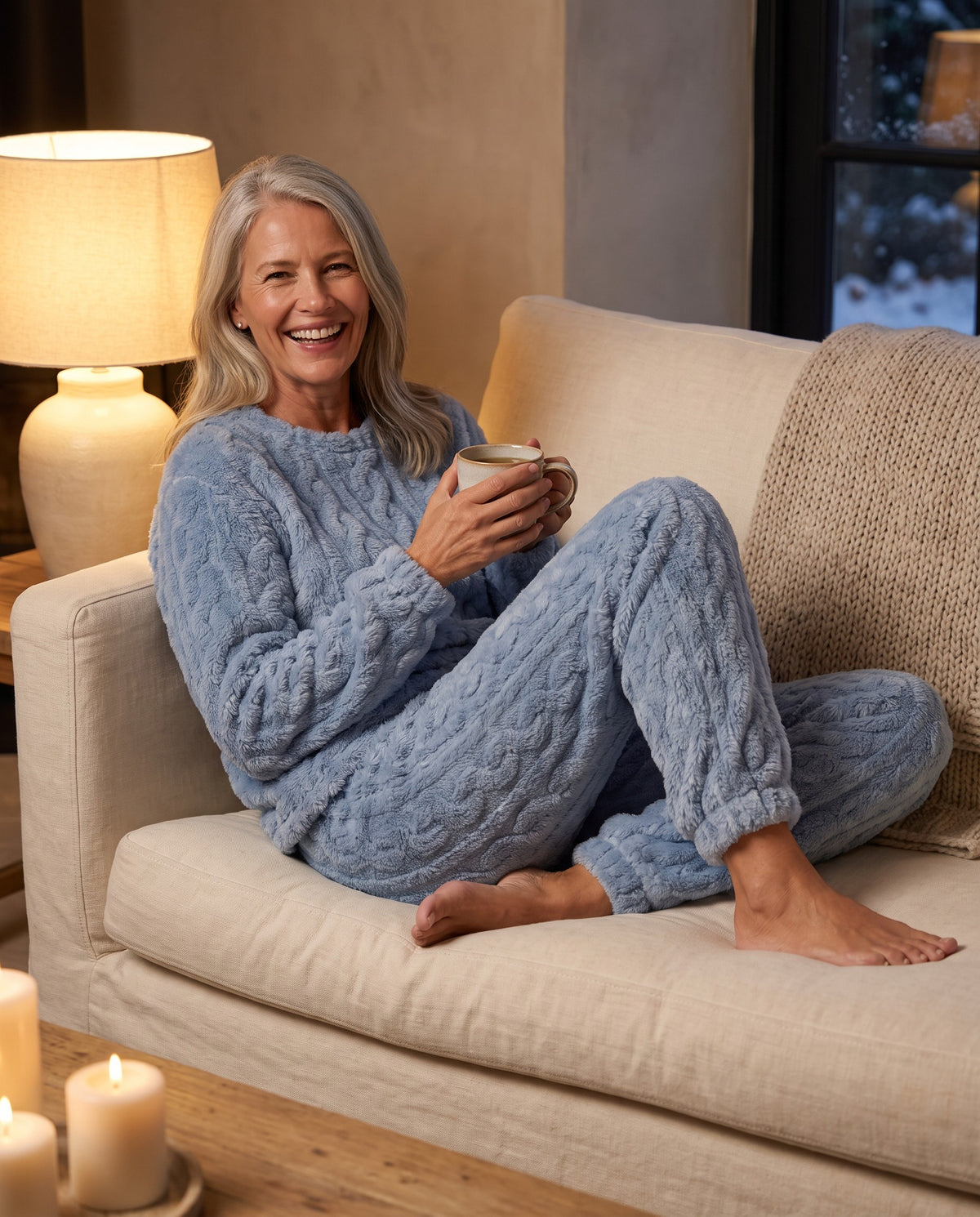 CLAIRE cable lounge set in Sky Blue, curled up on the sofa with tea